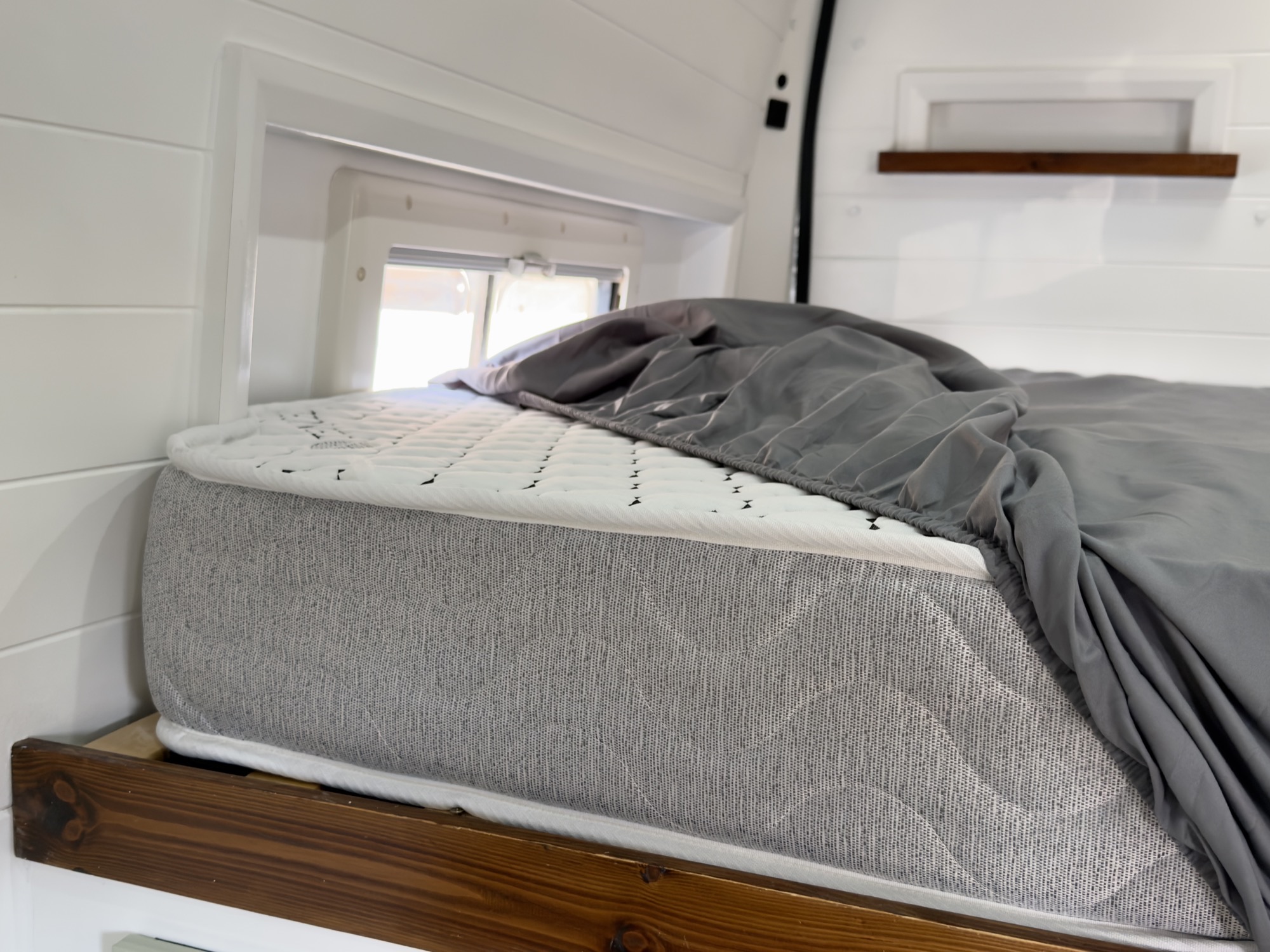 Side view of the custom mattress showing the depth and quilted top in the van