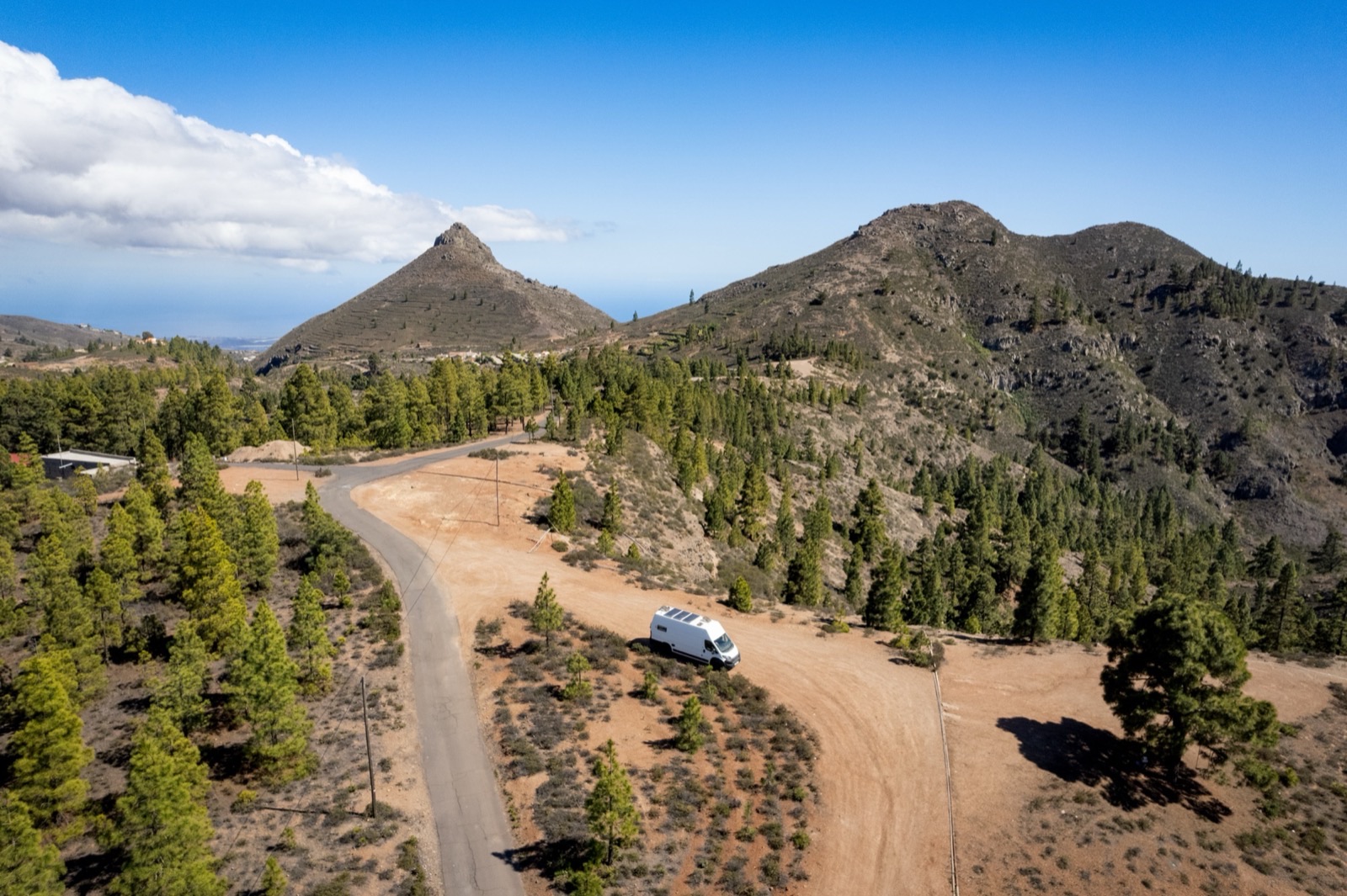 Aerial view of a campervan in a clearing surrounded by Portuguese mountain forest